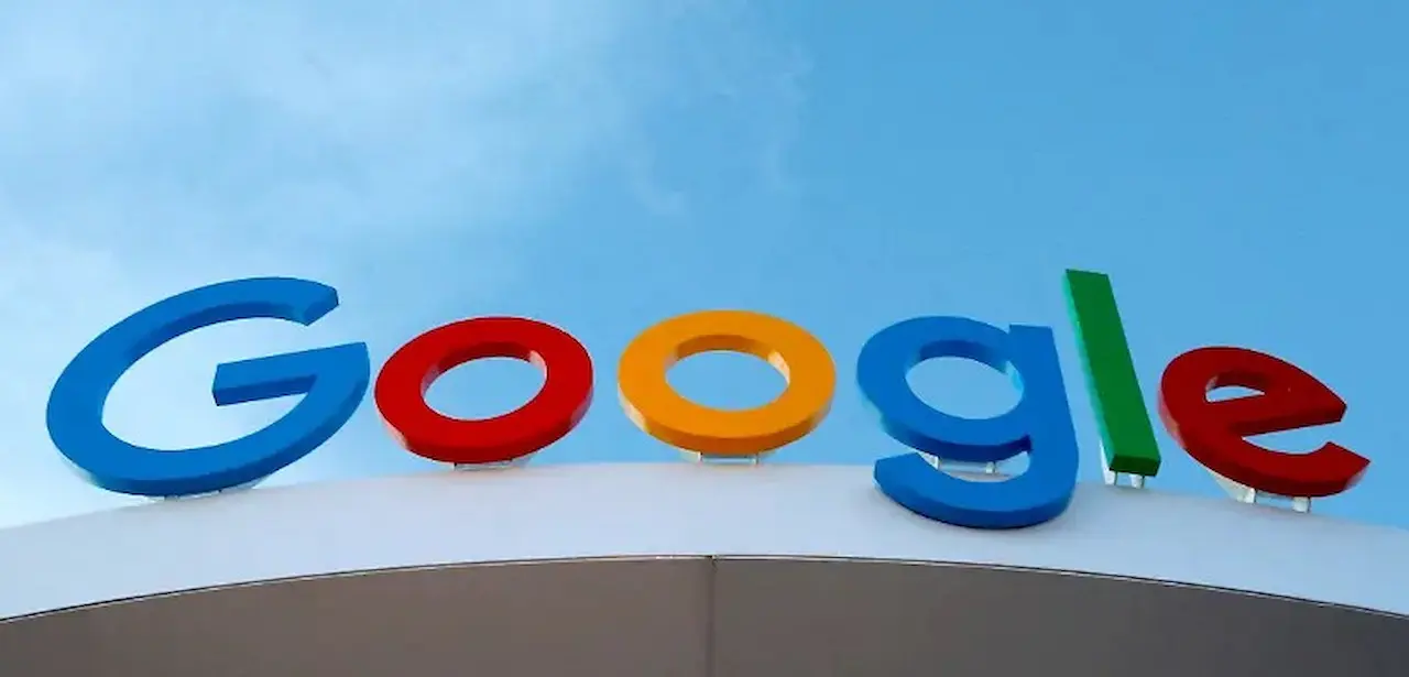 Logo Google en lettres tridimensionnelles colorées sur le toit d'un bâtiment sous un ciel bleu